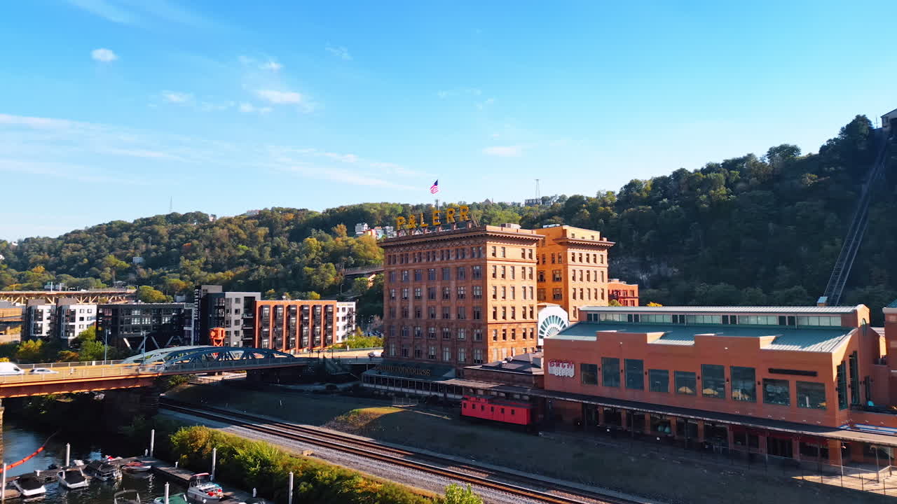 Piyysburgh, USA, 3 August 2025: Historic red brick building in Pittsburgh. Old red brick building with sign and surrounding modern structures in Pittsburgh