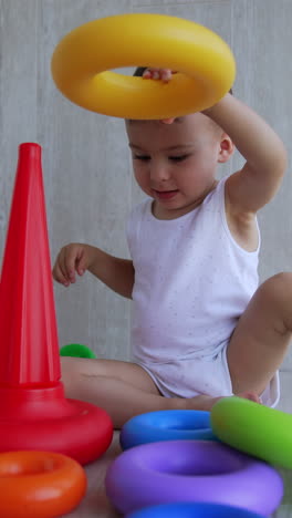 baby playing with colorful rings and cones