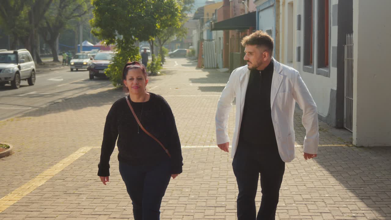 Two People Walking on an Urban Sidewalk