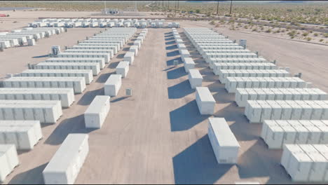 un dron vuela a través de unidades de almacenamiento cuidadosamente alineadas en una instalación del gobierno de estados unidos en el desierto de california, capturando el diseño organizado contra el telón de fondo de montañas lejanas.