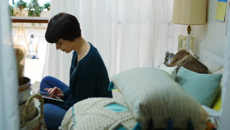 woman using digital tablet in bedroom