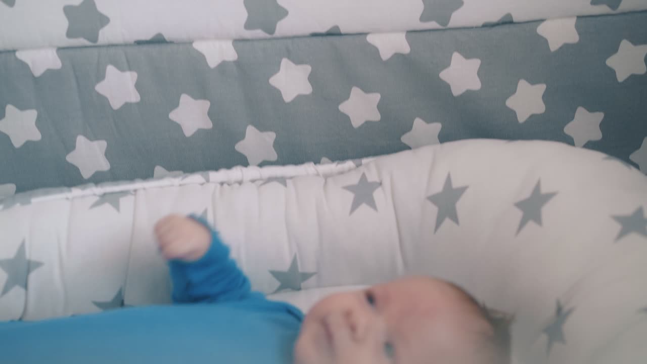la mamma scuote il sonaglio su un bambino giocoso nel bozzolo
