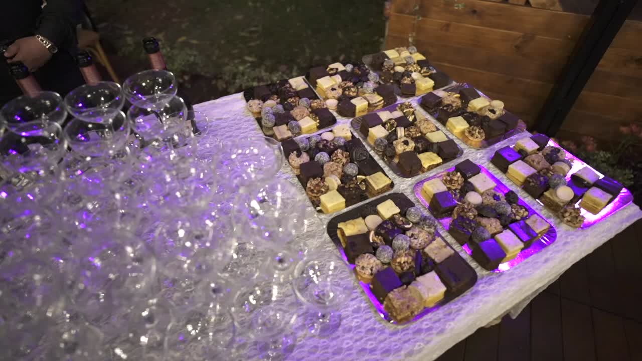 Nærbillede af et sortiment af mini dessertborde med champagneglas ved et elegant arrangement