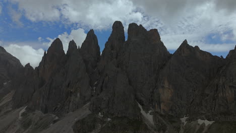 이탈리아의 돌로마이트 산맥 (dolomites) 의 울불하고 높은 봉우리를 촬영한 공중 영상, 구름이 굴러오는 역동적인 하늘을 배경으로