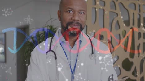 Animación-De-Cadenas-De-ADN-Y-Moléculas-Sobre-Un-Médico-Afroamericano-Sonriente-En-El-Hospital.