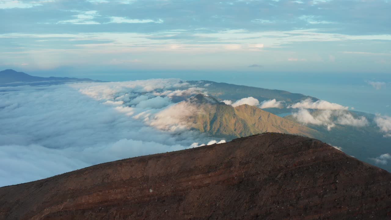 Sunrise Aerial View of a Volcano Mountain Top and Cloudy Valley. Close Up of the Ridge. Pan to right. 4k Footage.