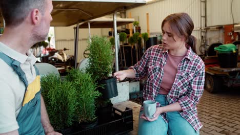 Two-caucasian-botanists-having-coffee-break-during-working-in-greenhouse