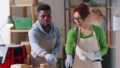 diversos compañeros de trabajo preparando comida para la entrega en la cocina fantasma