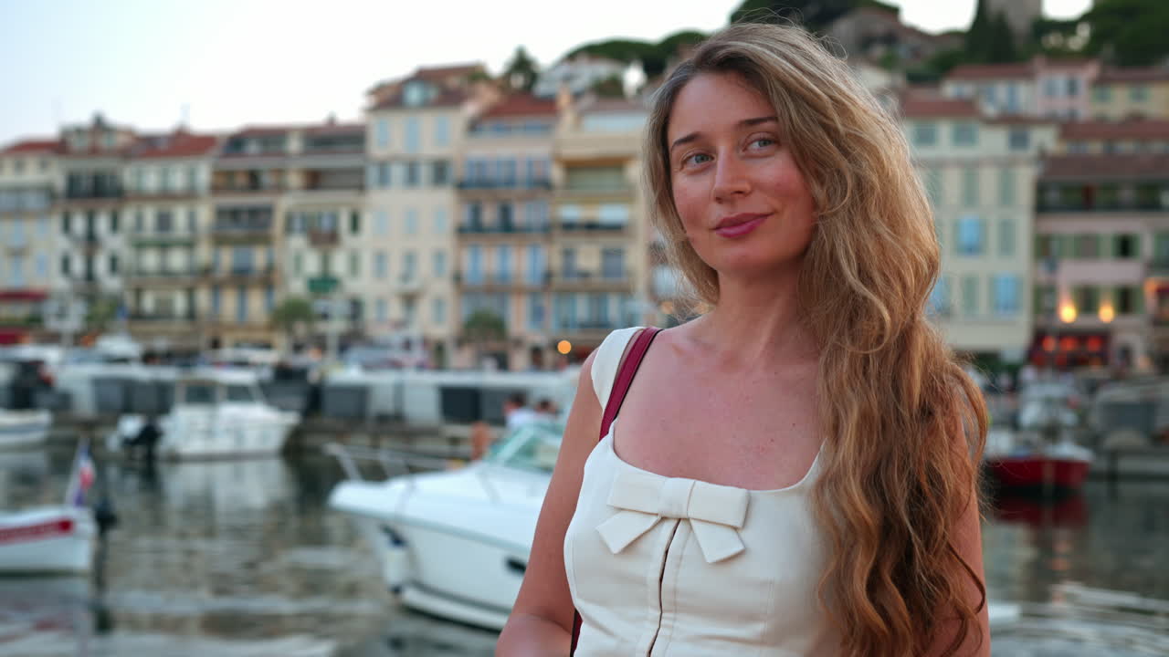 Woman posing in front of boats docked in the Port de Cannes, France
