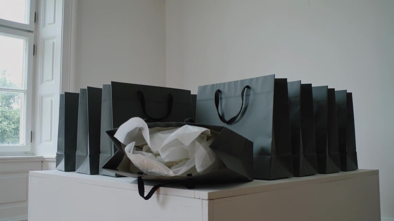 Surging tissue inside front bag of dark bag row causing collapse onto white plinth, window trees