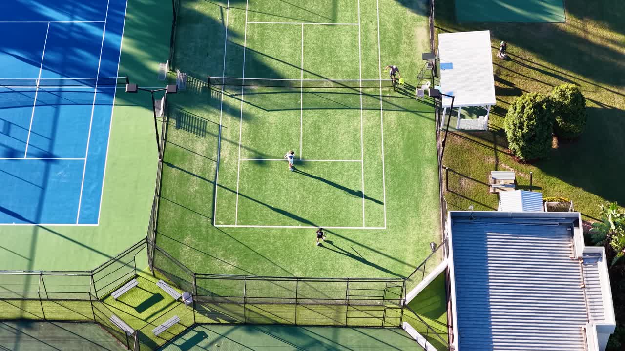 Drone footage captures a tennis match on vibrant courts in Gold Coast, Australia, highlighting dynamic play and sunny conditions