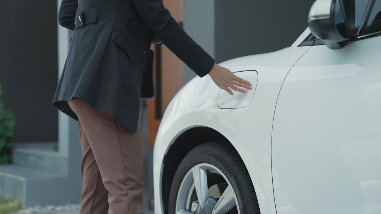 전기 자동차를 위한 가정 충전 스테이션을 갖춘 진보적인 가족의 개념입니다.