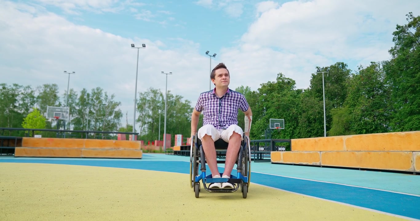 Joven en silla de ruedas sentado en una cancha deportiva al aire libre