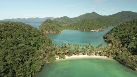 forward aerial dolly of tropical islands, turquoise waters with white sand beach, palms and sand bar