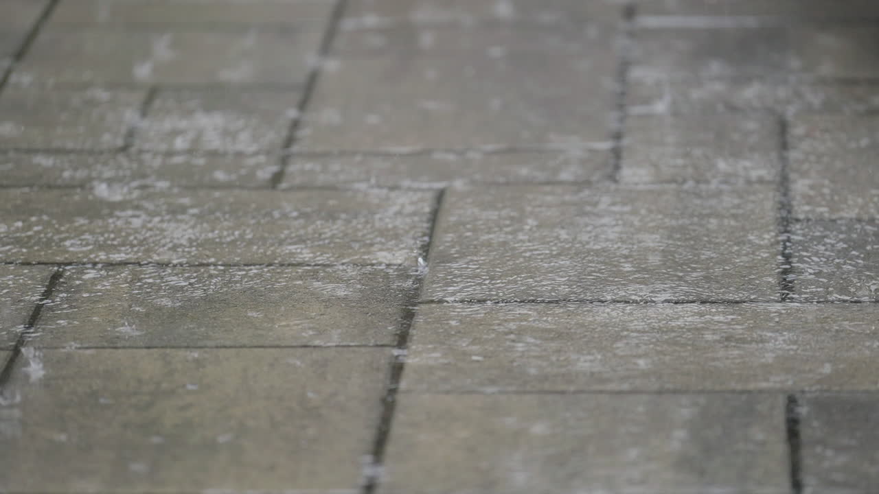 Slow motion rain on concrete, peaceful mood with gentle impact