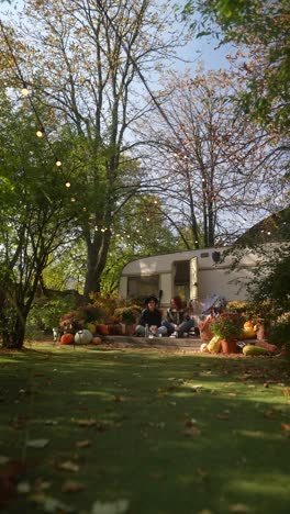 friends relaxing in garden with trailer