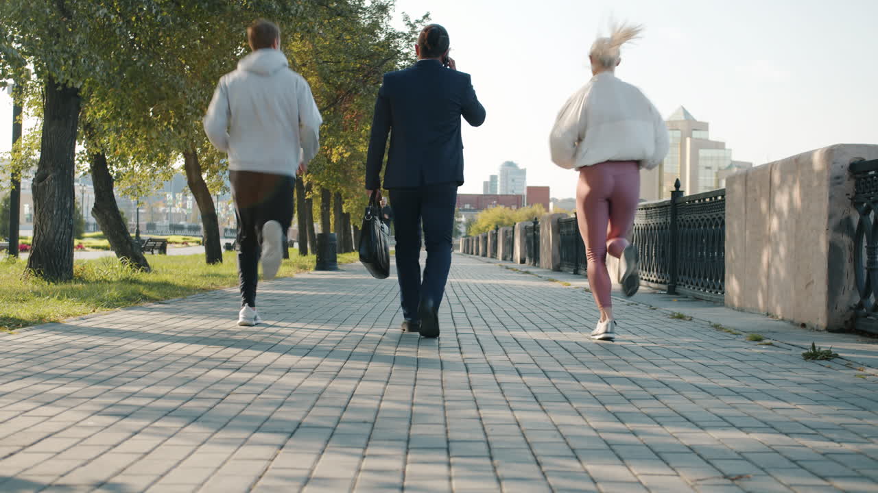 People Walking and Running in a City Park