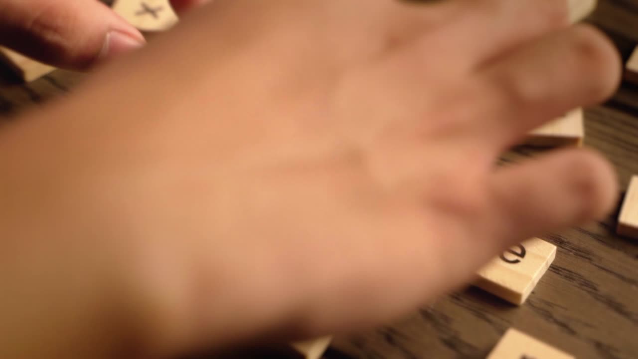 Wooden tiles spell the word serene on a wood surface with cinematic warm lighting.