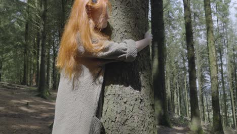 Girl-hugging-tree-in-pool-of-sunlight-in-forest-in-summer-at-half-speed-slow-motion