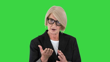 senior businesswoman executive teacher looking at camera talking on a green screen, chroma key