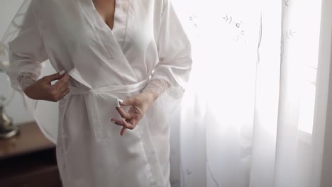 bride getting ready in a white robe