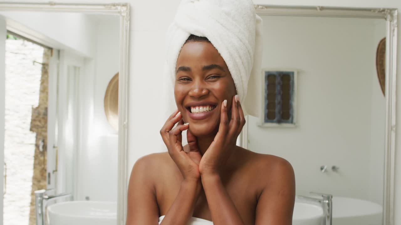 Vídeo de mulher afro-americana feliz de roupão sorrindo para a câmera