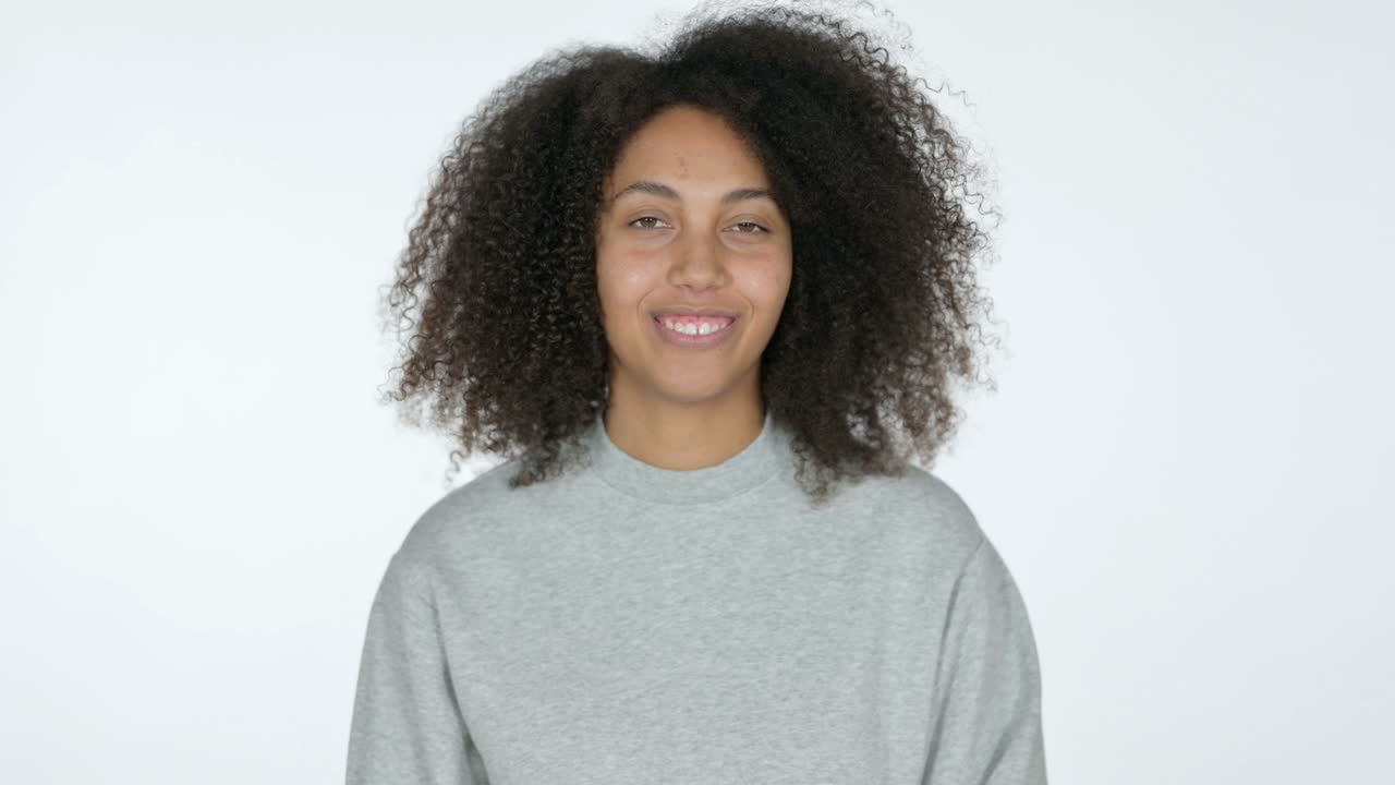 joven africana sonriendo a la cámara, fondo blanco