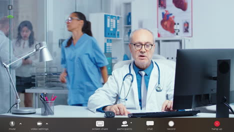 médico generalista senior mirando una cámara web hablando con pacientes