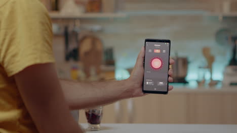 Mann-Hält-Smartphone-Mit-Lichtsteuerungsanwendung-In-Der-Hand-Und-Schaltet-Das-Licht-Ein
