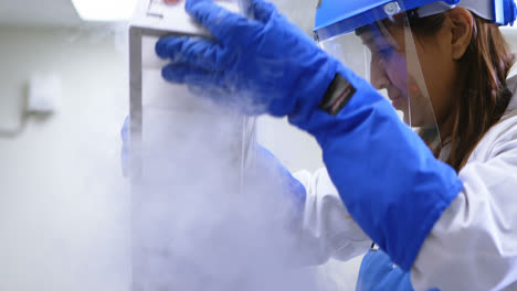 scientist removing vertical freezer rack from freezer 4k