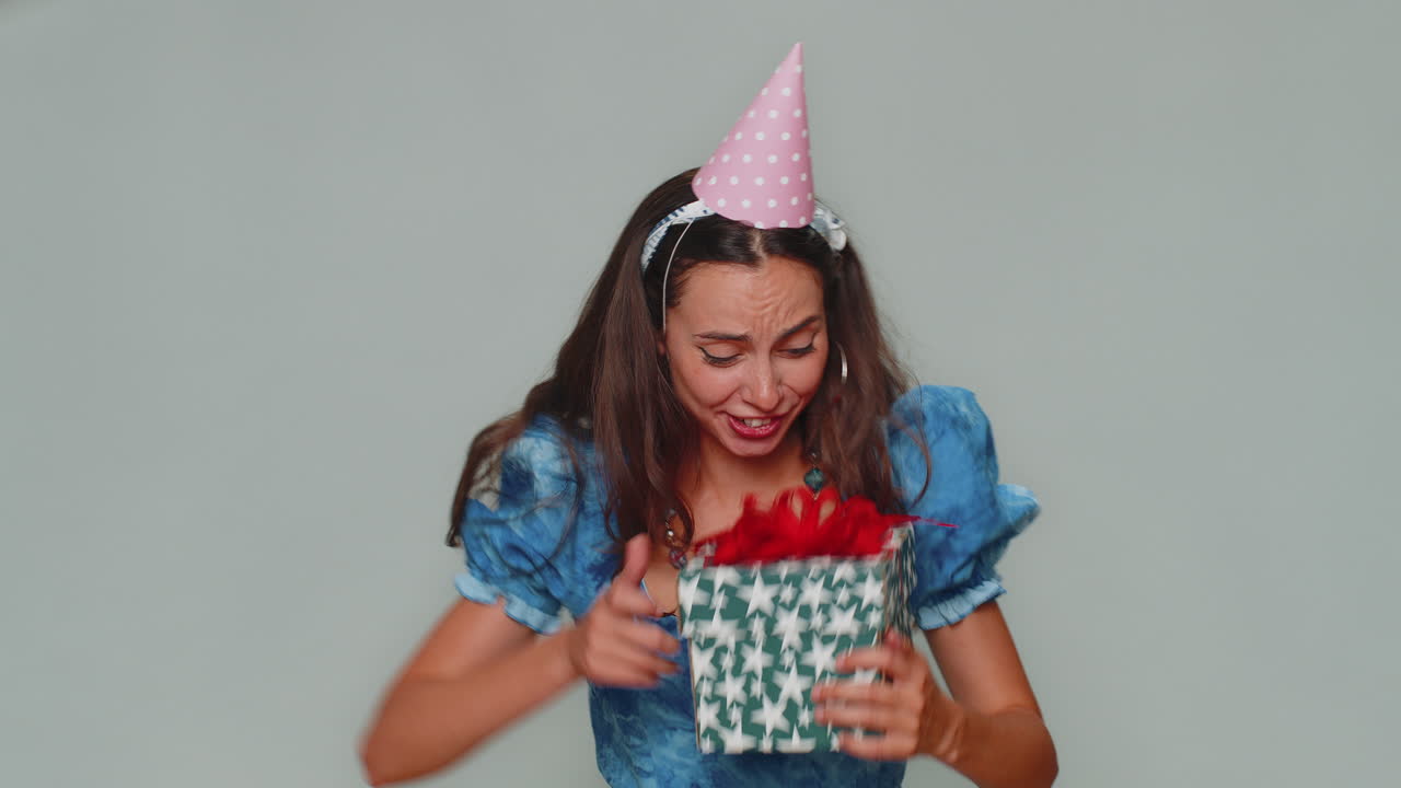 Mujer sonriente recibiendo una caja de regalo, asombrada y satisfecha con un bonito presente, una sorpresa de cumpleaños inesperada.