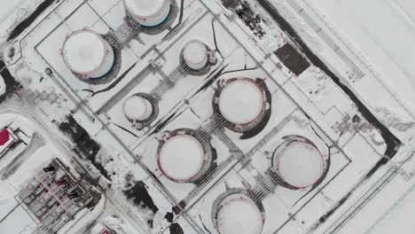 un dron vuela sobre tanques de petróleo en un paisaje de invierno. la industria del petróleo y el gas en los países nórdicos. crisis de combustible en invierno. producción de petróleo y gas en canadá o rusia.