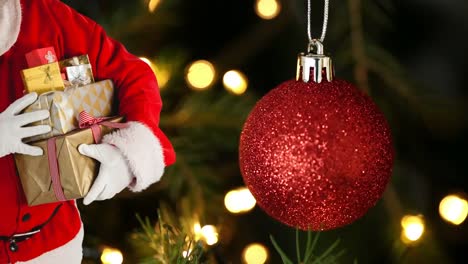 animación de santa claus sosteniendo regalos de navidad sobre bolas rojas manchas de luz naranja