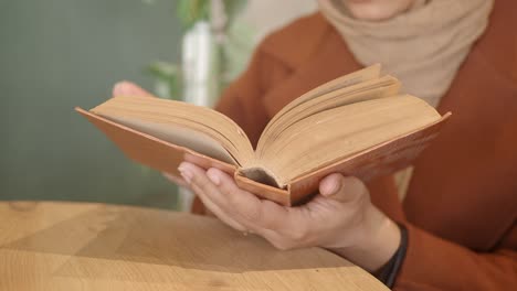 woman reading a book at a table