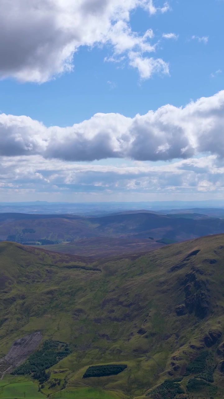 Drone che sorvola le dolci Highlands scozzesi, rivelando valli di erica, cime spettacolari e nuvole in movimento.