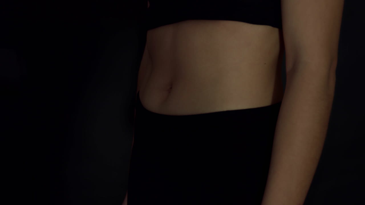 Woman with confidence showing the result of fitness exercising in the gym. Determination of woman exercising for abs muscle. Woman call attention to workout as a step for perfect fitness