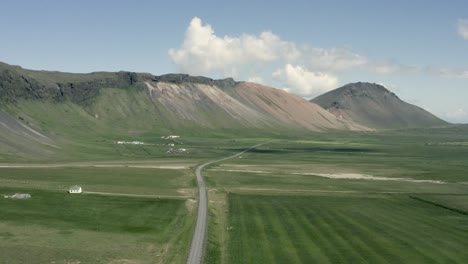 antena de un vasto paisaje verde con montañas elevadas en un día soleado, islandia