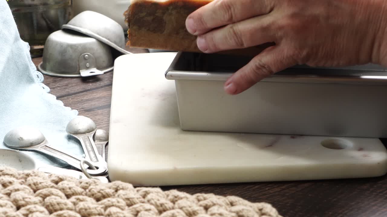 Baking delicious caramel pecan brownies. Taking brownies out of the pan and putting them on a marble cutting board.. Baked gooey chocolate brownies with sweet caramel and nutty pecans.