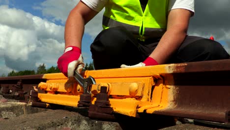 trabajador que fija tuercas con llave inglesa en el ferrocarril