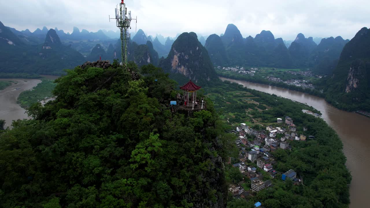 Drone dolly to hikers on Laozhai Hill pagoda overlooking Li River
