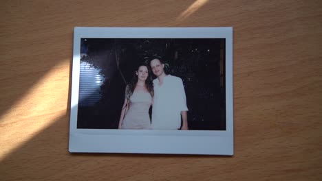 foto polaroid de una pareja en una mesa de madera