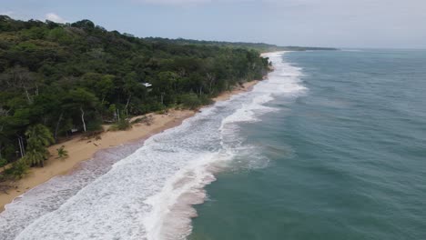 Sandy-beach-Bluff-with-waves-for-surfers,-exotic-destination-in-Panama,-Bocas-del-Toro,-aerial