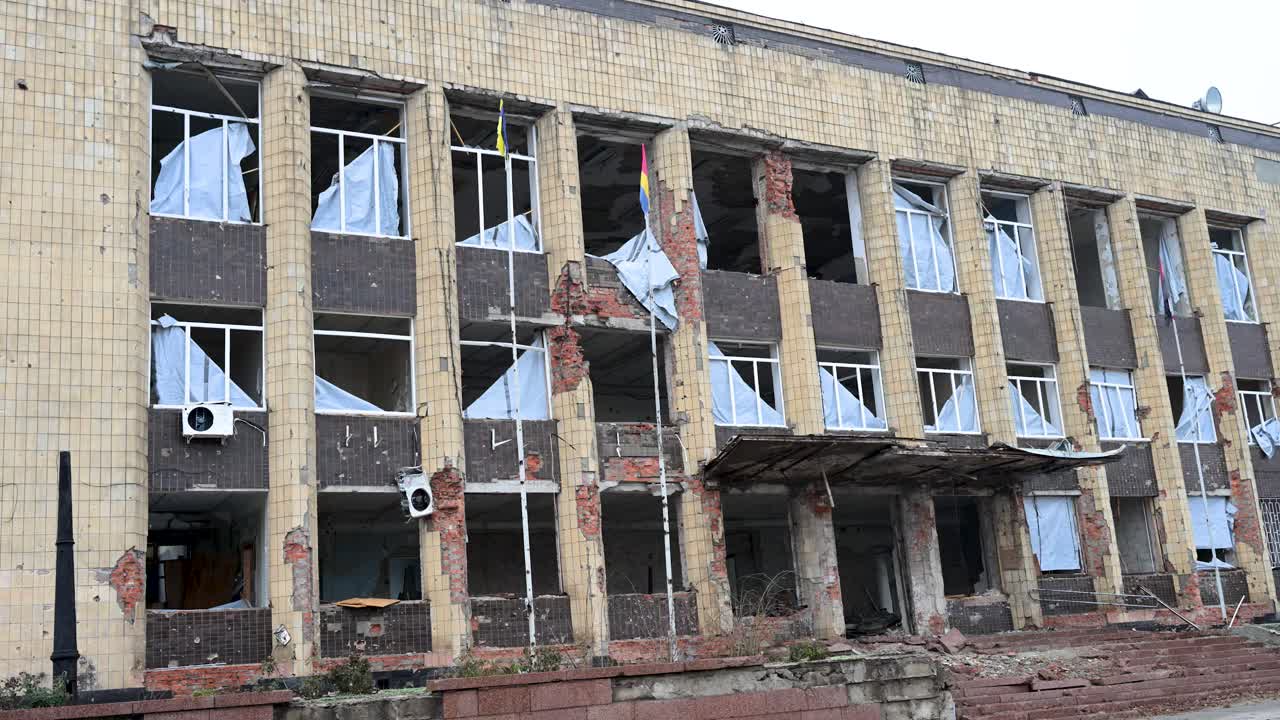 A close-up of the Kupiansk Palace of Culture reveals the severe aftermath of Russian shelling. The shattered facade, blown-out windows, and rubble detail the destruction on the frontline