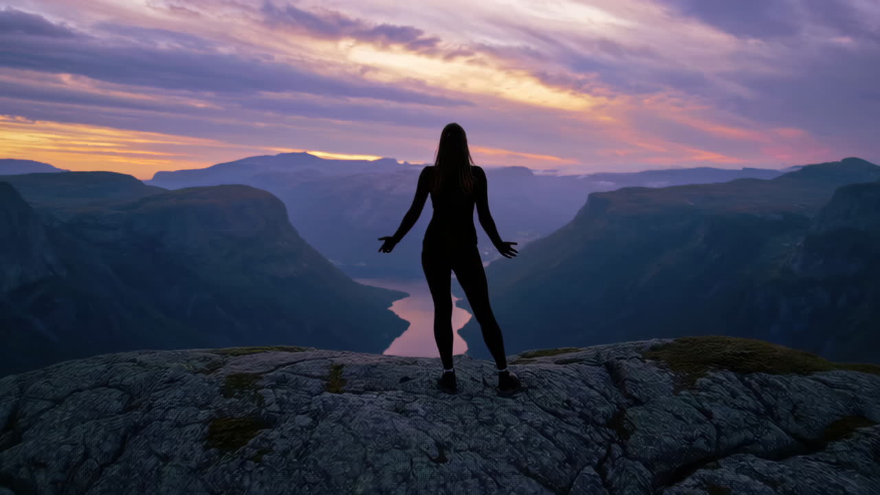 Woman on a Mountain Peak at Sunset