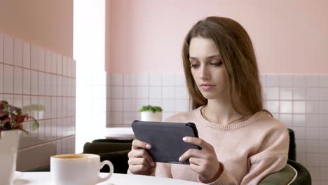 hermosa y elegante mujer caucásica usando una tableta, enviando mensajes de texto, escribiendo. sonriendo, mirando hacia otro lado 60 fps