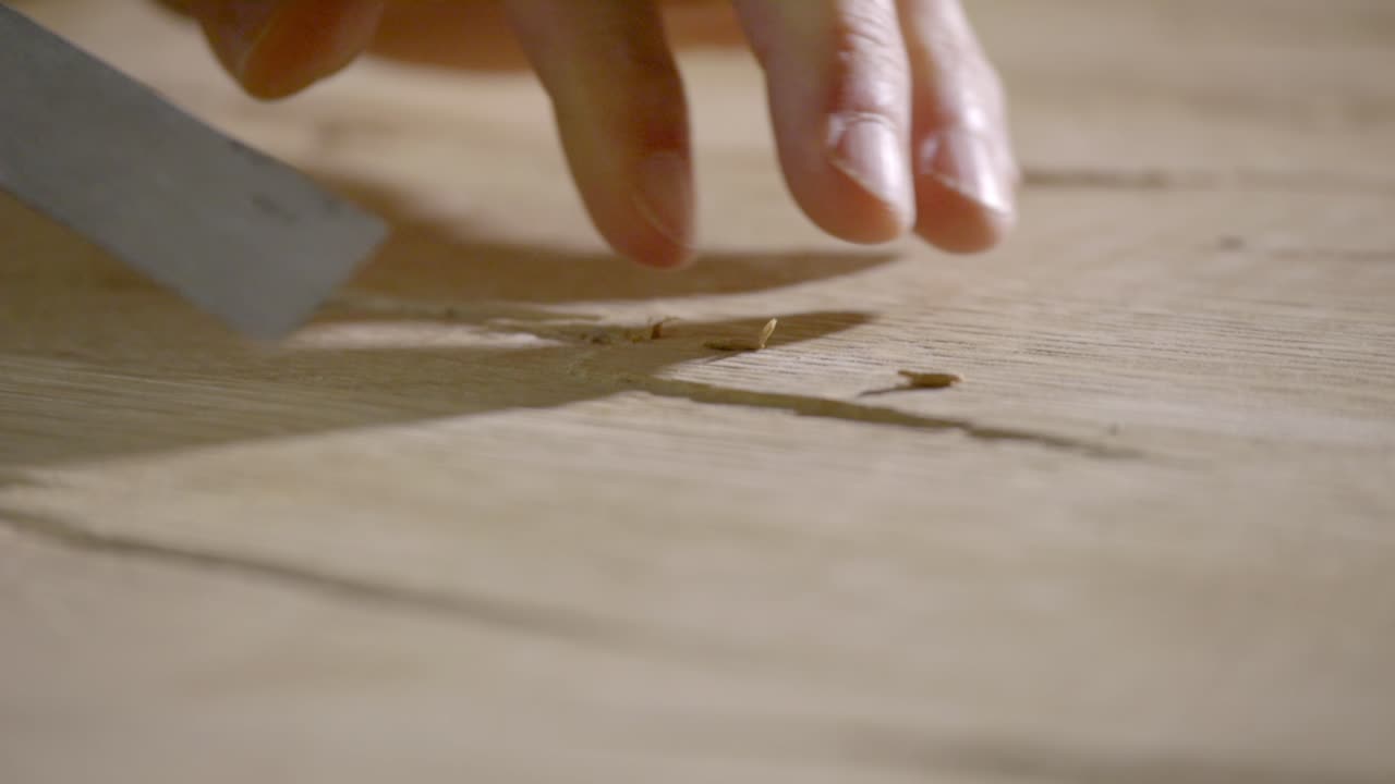An artisan carves a piece of wood manually