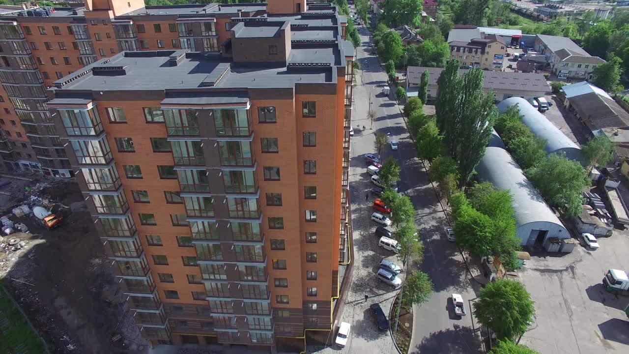 Aerial shot of the modern town houses of brick and glass on urban street