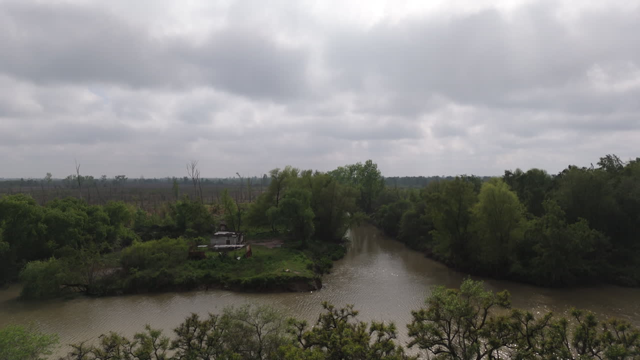 Isolated island with abandoned house on misty river, surrounded by dense green forest