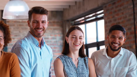 Portrait-Of-Smiling-Multi-Cultural-Business-Team-Standing-Together-In-Modern-Office