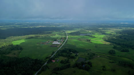 Clouded-Sky-Over-Evergreen-Countryside-With-Vegetation-And-Meadows